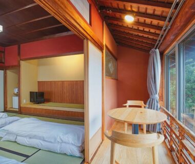Tatami room with futon bedding, shoji screens and wooden balcony at Katsuzakikan in Chūbu, Ishikawa, Japan