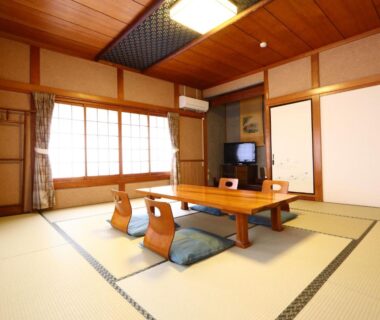 Traditional tatami room with low table, zaisu chairs, shoji windows and fusuma at Kawachiya Ryokan in Mie