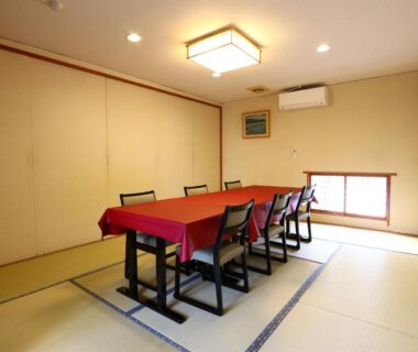Tatami room with long dining table and chairs, red tablecloth, Kawachiya Ryokan, Mie, Japan