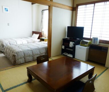 Tatami room with low table, western bed and shoji screens at Kawaguchiko Lakeside Hotel, Yamanashi