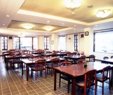 Spacious tiled dining room with wooden tables and large windows at Kawaguchiko Lakeside Hotel Yamanashi
