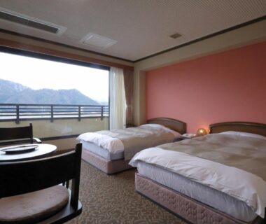 Twin beds with balcony and mountain view at Kawaguchiya Kinosaki Riverside Hotel, Hyōgo, Kansai