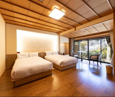 Twin beds and low table by large window overlooking garden at Kawakamiya Kasuitei, Gifu, Chūbu, Japan