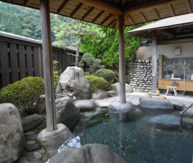 Covered rock-lined onsen bath with garden shrubs at Kawakamiya Kasuitei, Gifu, Chūbu, Japan