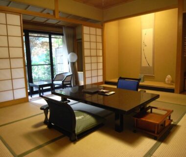 Tatami room with low table, cushions, shoji screens and garden view at Kawakamiya Kasuitei in Gifu