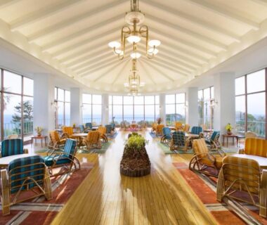 Airy lounge with vaulted ceiling, chandeliers and panoramic windows at Kawana Hotel Shizuoka