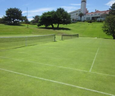 Grass tennis court with net and hotel building backdrop at Kawana Hotel, Shizuoka, Chūbu, Japan
