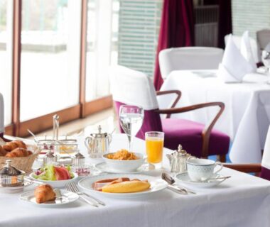 White-clothed breakfast table with bread, fruit and orange juice at Kawana Hotel, Shizuoka, Chūbu, Japan