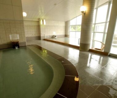 Tiled indoor onsen bath with large windows at Kawayu Kanko Hotel, Hokkaidō
