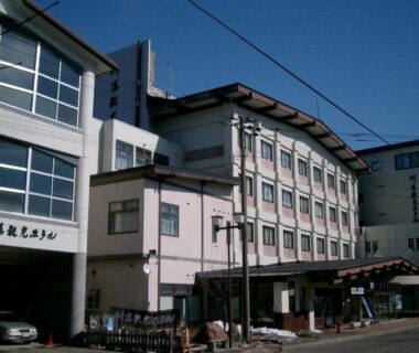 Multi-story ryokan building with entrance canopy and street view at Kawayu Kanko Hotel in Hokkaidō