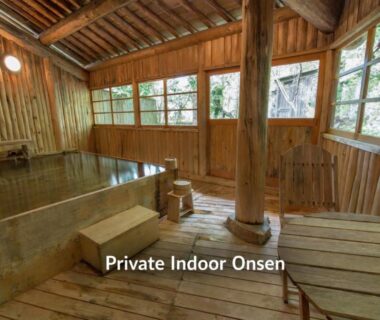Rustic timber indoor bath with soaking tub, large windows and wooden decking at Kazeya in Gifu