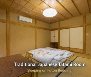 Traditional tatami room with futon bedding, low wooden table, sliding doors and ceiling light at Kazeya, Gifu