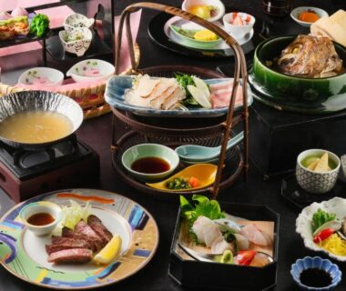 Assorted kaiseki dishes with simmering pot and ceramic bowls at Keishokan Sazanamitei, Hiroshima