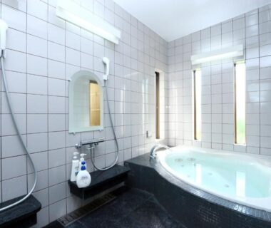 Tiled indoor bathing room with jacuzzi tub and shower stations at Kii no Matsushima, Mie