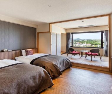 Two beds, seating area and large window with landscape view at Kiki Shiretoko Natural Resort, Hokkaidō