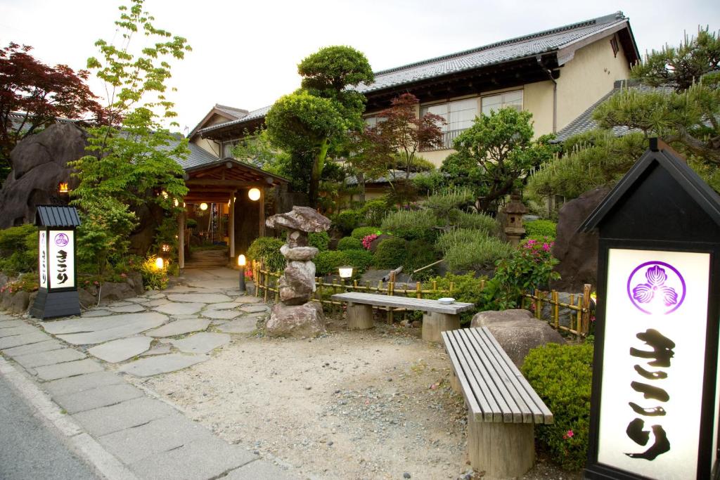 Ryokan entrance and garden Kikori Yamanashi Stone path, lanterns and manicured shrubs leading to wooden ryokan entrance at Kikori, Yamanashi