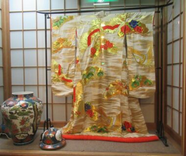 Ornate brocade kimono displayed with shoji screens at Kikuchi Kanko Hotel in Kumamoto