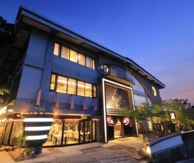 Kikunoya ryokan exterior at dusk with illuminated entrance and traditional multi story facade in Hiroshima