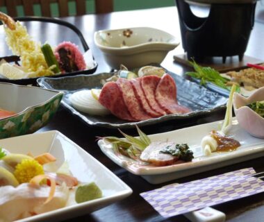 Assorted Japanese dishes with tempura, sashimi, sliced beef and small side bowls at Kimimachisou, Nagano