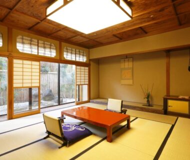 Traditional tatami room with low table, floor chairs, shoji screens and garden view at Kinjohro in Ishikawa