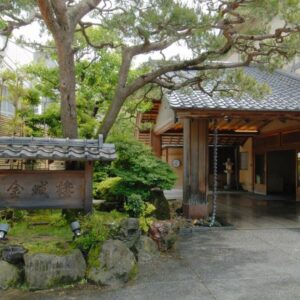Wooden entrance with stone signboard and pine tree at Kinjohro in Chūbu, Ishikawa