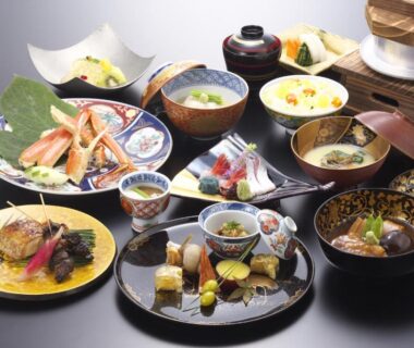 Assortment of small plated Japanese dishes on lacquer trays at Kinjohro in Chūbu, Ishikawa, Japan