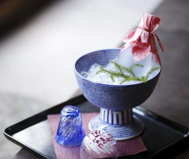 Decorative ceramic bowl with cloth-wrapped bundle and two small glass cups on lacquer tray at Kinjohro, Ishikawa, Chūbu, Japan