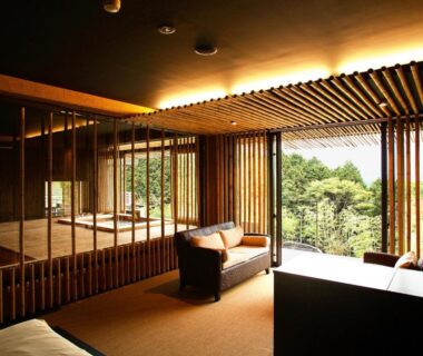 Spacious tatami lounge with wooden slats and low seating at Kinnotake Sengokuhara, overlooking verdant Kanagawa hills