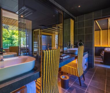 Modern ensuite with freestanding bathtub, twin sinks, striped chairs and garden view at Kinnotake Sengokuhara in Kanagawa