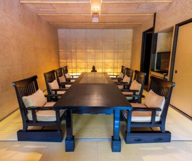 Low dining table on tatami with wooden armchairs and shoji screen at Kinnotake Sengokuhara in Kanagawa