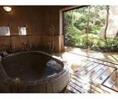 Stone-lined wooden soaking tub opening onto a small garden and wooden deck at Kinokuniya Jinpachi, Nara