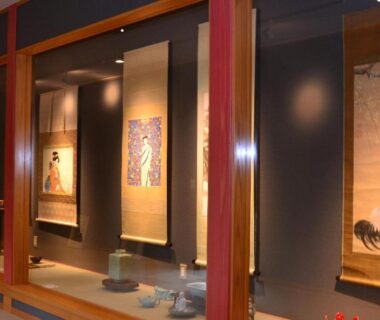 Alcove display with hanging scrolls and ceramics along wooden corridor at Kinokuniya Ryokan in Kanagawa