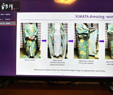 TV screen showing step-by-step women's yukata dressing instructions at Kinosaki Onsen Hanakouji Saigetsu, Hyōgo