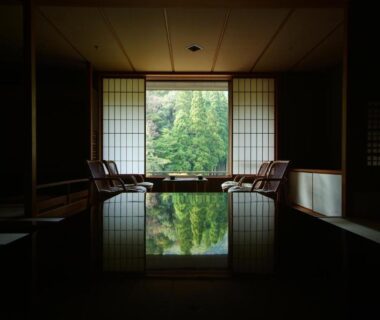 Indoor reflecting onsen pool framed by shoji screens with garden view at Kinosaki Onsen Nishimuraya in Hyogo