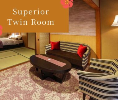 Tatami room with sofa, low table and twin beds at Kinosaki Tenboen in Hyogo