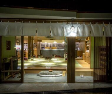 Traditional noren and sliding doors opening to a warmly lit tatami lobby at Kinosaki onsen Tokitotoki, Hyōgo