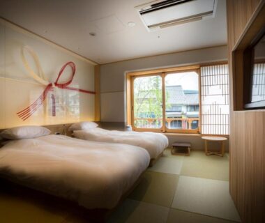 Tatami room with twin beds, shoji window and small garden view at Kinosaki onsen Tokitotoki in Hyōgo