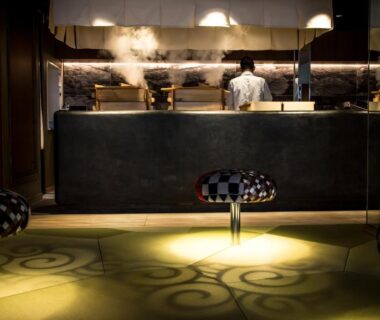 Ryokan reception with staff behind steaming counter and patterned carpet at Kinosaki onsen Tokitotoki, Hyōgo