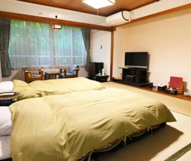 Tatami room with twin beds and low table at Kinosato Yamanoyu in Ōita, Kyūshū, Japan
