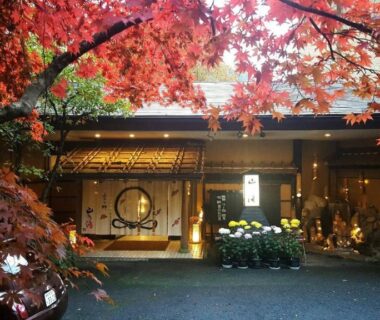 Entrance framed by red maple branches at Kinosato Yamanoyu in Ōita, Kyūshū
