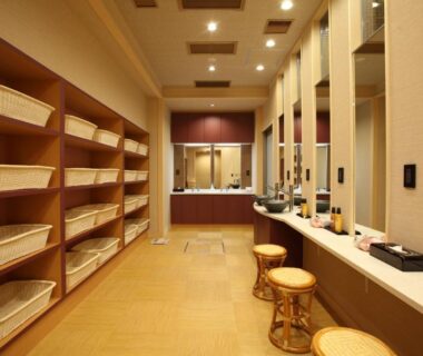 Wooden shelves with wicker baskets and stools in a ryokan changing area at Kinparo Kyoto