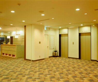 Spacious carpeted lobby with elevators and reception desk at Kinparo in Kyoto Kansai
