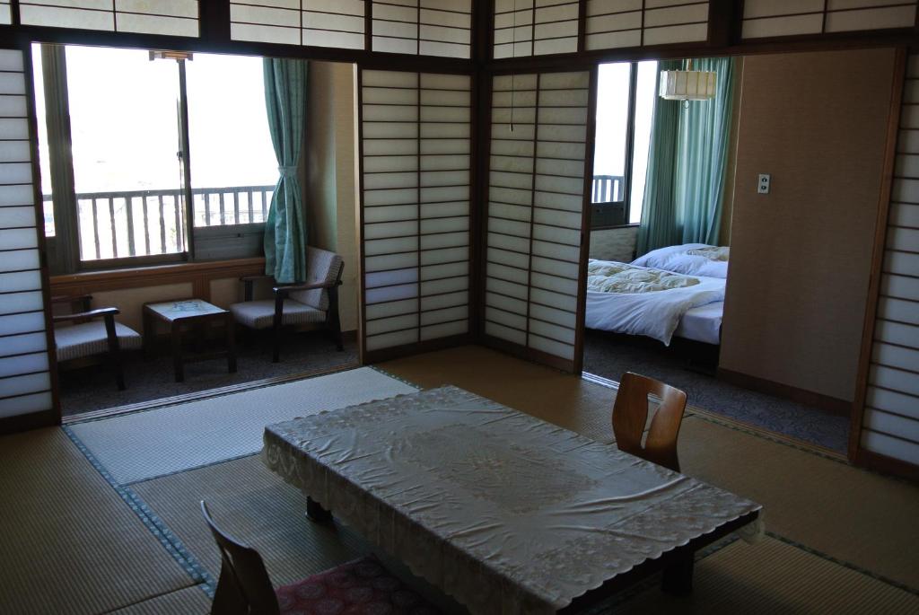 Tatami Room at Kinpokan Mie Kansai Tatami room with low table, low-back floor chairs, shoji screens and adjoining Western beds at Kinpokan in Mie
