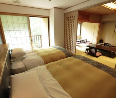 Ryokan room with twin beds, tatami seating, shoji screens and balcony at Kinseikan Seseragi in Gunma