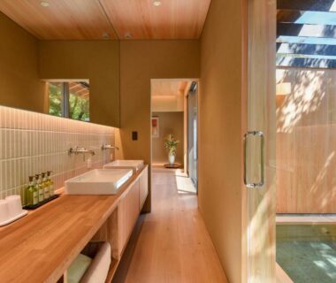 Wooden soaking tub with glass window, sink counter and natural light at Kinshuusanso in Gunma