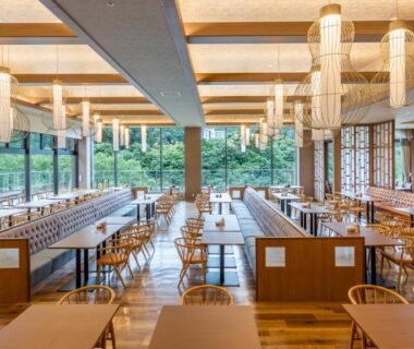 Spacious dining room with wooden tables and lantern-style pendant lights at Kinugawa Hotel Mikazuki, Tochigi, Japan
