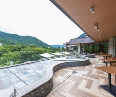 Terrace with stone soaking baths and seating overlooking forested mountains at Kinugawa Hotel Mikazuki, Tochigi