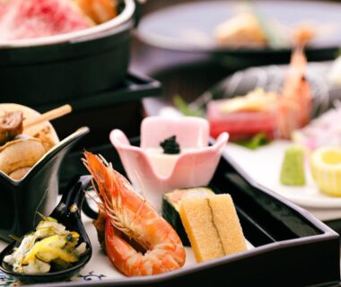 Assorted Japanese dishes with shrimp, tamagoyaki and pickles in lacquered trays at a ryokan meal