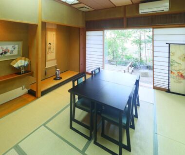 Tatami room with dining table and shoji doors opening to garden at Kinugawa Onsen Matsuya, Tochigi