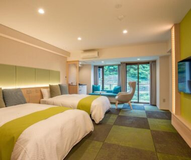 Modern twin beds with green accents and garden view through sliding doors at Kinugawa Onsen Hotel, Tochigi